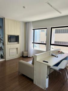 ein Wohnzimmer mit einem Sofa und einem Schreibtisch mit einem TV in der Unterkunft Flat exclusivo vista mar in Recife + 33 Fotos