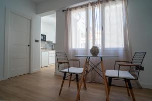 una sala da pranzo con un tavolo e due sedie di Apartamentos Gomérez 30 a Granada