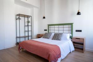 una camera da letto con un letto grande e uno specchio di Apartamentos Gomérez 30 a Granada