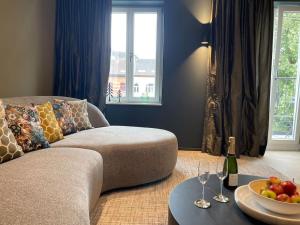 a living room with a couch and a bowl of fruit on a table at La Suite by Villa Raphaël in Spa
