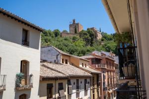 una vista di una città con edifici e un castello di Apartamentos Gomérez 30 a Granada