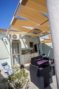 a patio with a roof with a table and chairs at La casa del pescatore in Oliveri