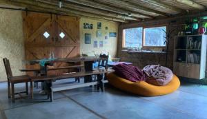 a room with a wooden table and a bench and a table and chairs at Casa Qinti EcoHostel in Cosquín