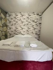 a bed in a room with a brick wall at Sohbet Beach otel in Narlı +4 photos