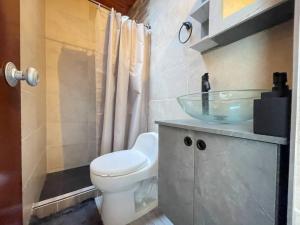 a bathroom with a toilet and a glass sink at Magnífica y Acogedora Casa en Condomiminio in Jamundí +31 photos
