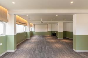 an empty room with green walls and a whiteboard at Spektrum Hotel - Bengaluru Airport in Bangalore