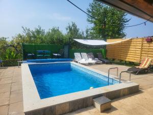 a swimming pool with chairs and a table at VIKENDICA GARFILD SA BAZENOM i SAUNOM BANJA LUKA in Banja Luka