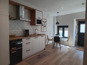 a kitchen with white cabinets and a table with chairs at Casa Loureiro in Redondela +14 photos
