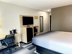 a bedroom with a bed and a desk and a television at Super 8 by Wyndham Cedar Rapids in Cedar Rapids