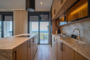 cocina con armarios de madera y vistas al océano en Villa Zoe, en Budva