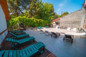 an outdoor patio with lounge chairs and a table at Kopala Tskneti Hotel in Tsqnetʼi