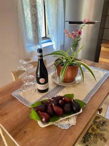 a table with a bottle of wine and a plate of fruit at Casa contadina nel verde ai piedi della Majella - Agricasa Caprafico in Casoli