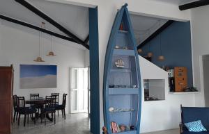 a living room with a surfboard leaning against a wall at CasaMar: confortável e decorada, 30km do Chuí in Santa Vitória do Palmar