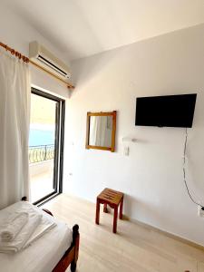 a bedroom with a bed and a flat screen tv on the wall at Kottas Apartments in Paralia Vrachou