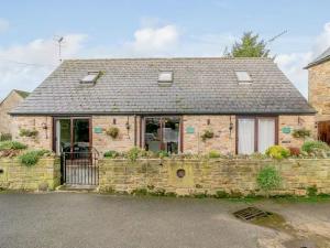 a brick house with a stone fence in front of it at Barlow Country Club - Mill Farm Cottages in Dronfield
