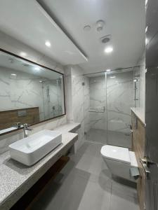 a bathroom with a sink and a toilet and a shower at Penta Square Apartments - PK LHR in Lahore