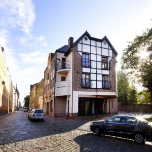 budynek na ulicy z samochodami zaparkowanymi przed budynkiem w obiekcie City Apartments - Apartamenty Butikowe w Koszalinie