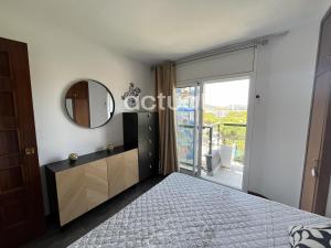 1 dormitorio con cama, espejo y balcón en Fanals 4M, en Platja d'Aro