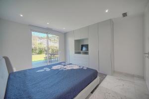 a bedroom with a blue bed and a large window at FRGK " Villa luxe grand loisir " in Mandelieu-la-Napoule +51 photos