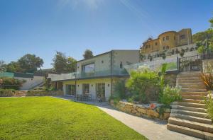a house with a staircase and a grass yard at FRGK " Villa luxe grand loisir " in Mandelieu-la-Napoule