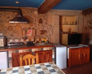 a kitchen with a sink and a counter with a refrigerator at LOS ORIZOS Sierra de Gata Extremadura TR-CC-00392 in Villamiel