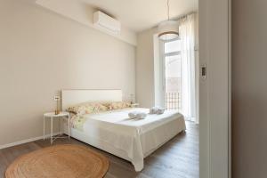 a white bedroom with a bed and a window at LAKE A DREAM for family free private parking in Arona