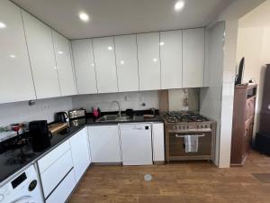 a kitchen with white cabinets and a sink and a stove at Casa Machado in Vila Real