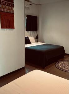 a bedroom with two beds and a mirror at Holland Lodge Paramaribo in Paramaribo