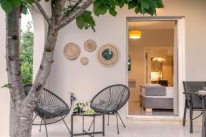 a patio with two chairs and a table and a tree at Marelia Garden House in Mytikas