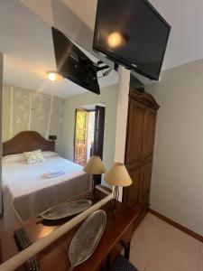 a bedroom with a bed with a desk and a television at El pucheru 4 Almas in Barcenaciones