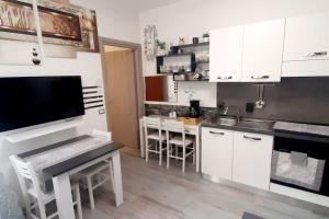 a kitchen with white cabinets and a sink and a table at La Casa al mare in Santa Marinella