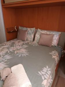 a bed with pink and white sheets and pillows at La Casa al mare in Santa Marinella