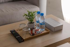a tray with water bottles and a remote control on a table at Luxurious Family Apartments 15Mins Drive to Al-Masjid Nabawi - Nozol Noor 4 in AR Rummanah