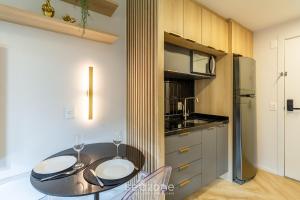 a kitchen with a table with two wine glasses at Studio de luxo e Sofisticado no Moinhos LBO203 in Auxiliadora