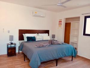 a bedroom with a bed with a blue blanket on it at Mar y Chelo Luxury Aparments in Isla Mujeres +75 photos