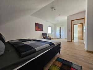 a bedroom with a bed and a chair in it at Haus des Schneiders in Büchenbeuren