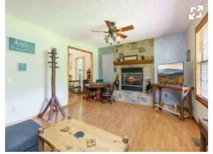 Una sala de estar con una mesa y una chimenea. en Riverside Dreamin, en Sevierville