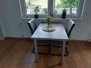 einen Esstisch mit Stühlen und eine Vase mit Blumen in der Unterkunft Ferienwohnung Moselliebe in Lehmen