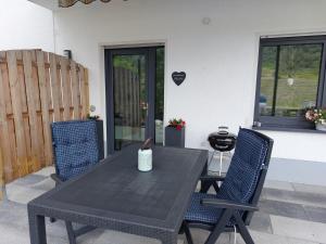 einen schwarzen Tisch und zwei Stühle auf einer Terrasse in der Unterkunft Ferienwohnung Moselliebe in Lehmen