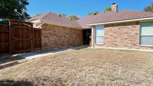 a house with a fence and a yard at Spacious Single-Story Plano Home in Plano