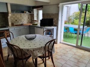 a kitchen with a table and chairs and a kitchen with a patio at Jardin clos et calme, vélos à disposition, plages à 2 kms in Tréffiagat