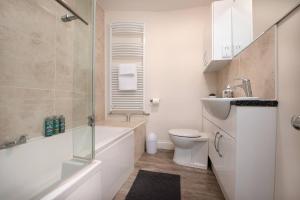 a bathroom with a tub and a toilet and a sink at St Jude's View in Portsmouth +12 photos