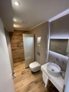 a bathroom with a white toilet and a sink at GeoMar Luxury Apartments in Skala Marion