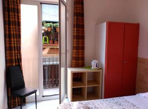 a bedroom with a red cabinet and a chair next to a window at Hostal River in Barcelona
