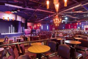 an empty room with tables and chairs and lights at Elite Retreat Blackpool in Blackpool