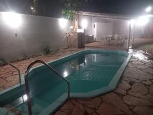 ein Schwimmbad in einem Garten in der Nacht in der Unterkunft Casa com piscina in Palmas