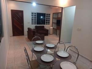 ein Esstisch und Stühle in einem Wohnzimmer in der Unterkunft Casa com piscina in Palmas