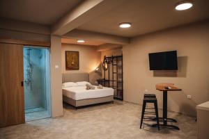 a bedroom with a bed and a television and a stool at Zen Apartments in Strumica