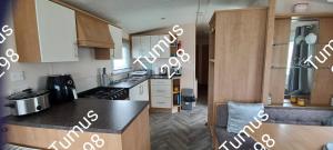 a kitchen with wooden cabinets and a counter top at Tumus 298 sandy cove 066 in Barmouth +5 photos