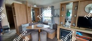 a small living room with a table and a tv at Tumus 298 sandy cove 066 in Barmouth